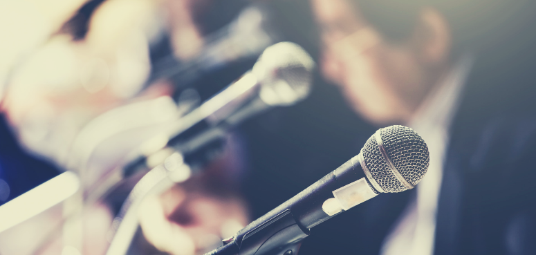 Man sitting at table with microphones 